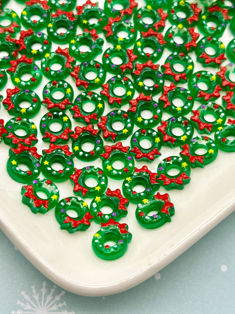 a white plate topped with lots of green and red beads