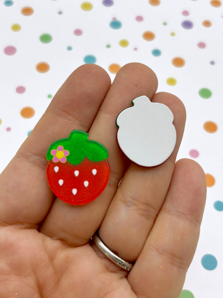 a hand holding a small strawberry and a white cloud