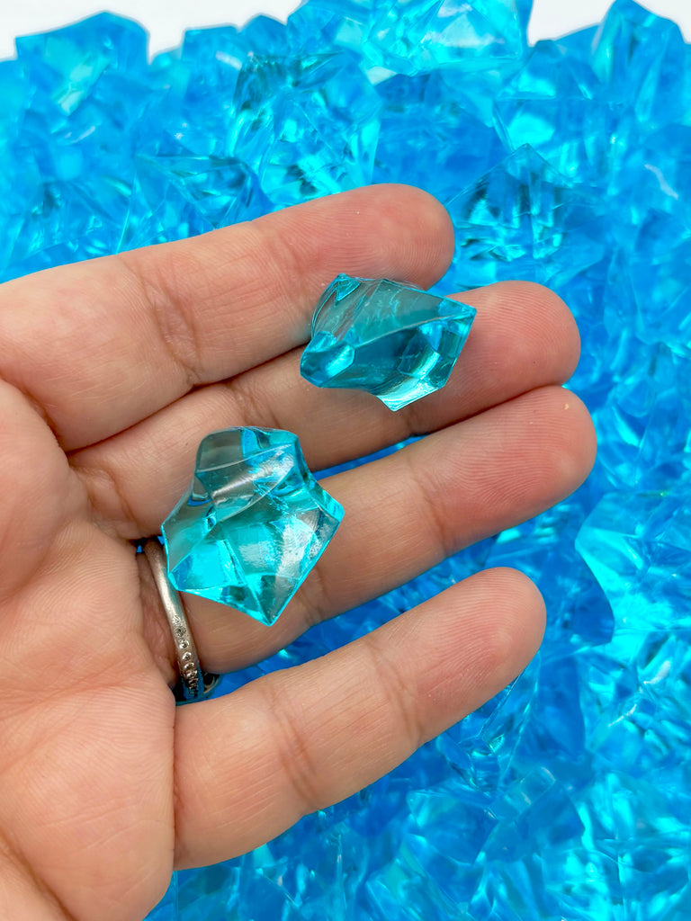 a person's hand holding two blue rings