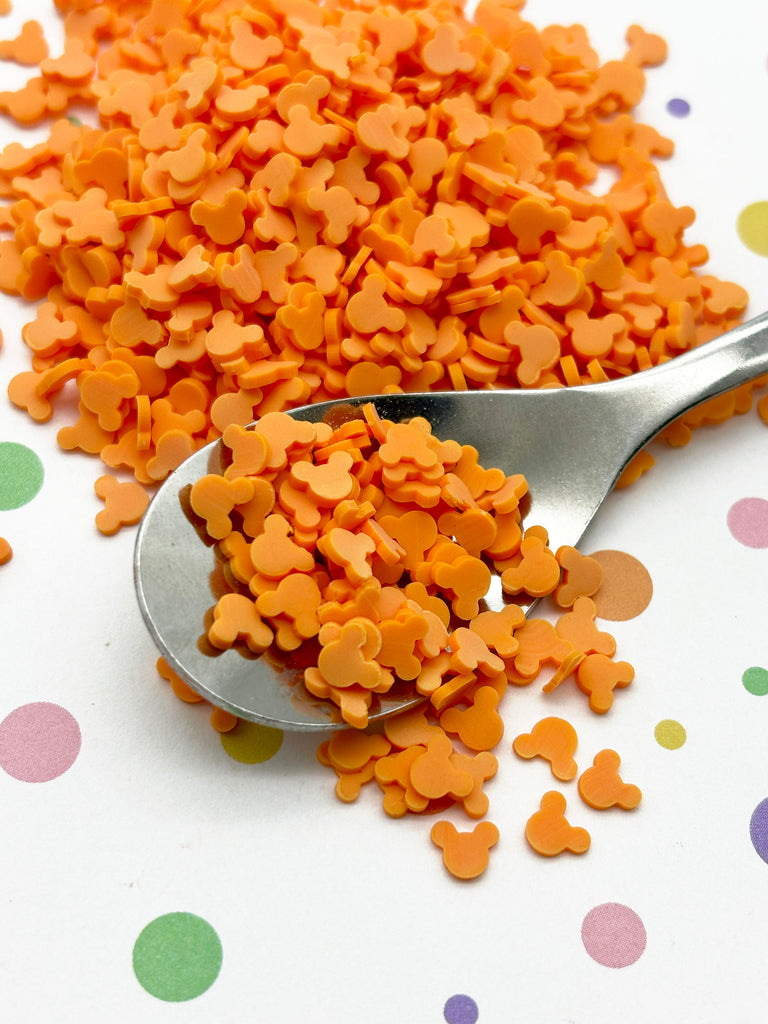 a spoon full of orange dog treats on a polka dot tablecloth