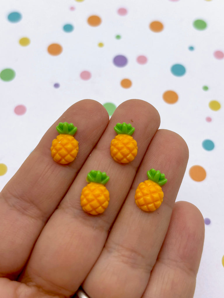 a hand holding three tiny pineapples on it's fingers