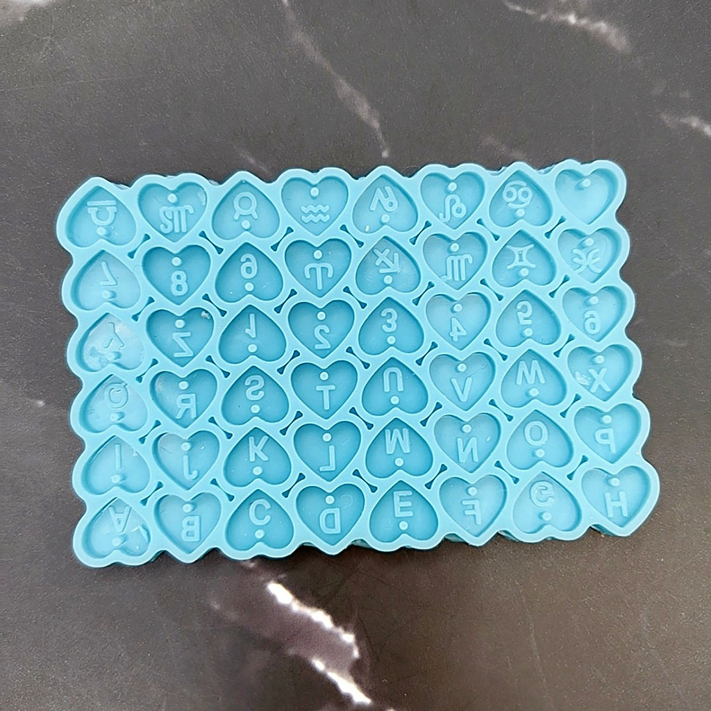 A blue heart-shaped alphabet mold with the letters of the alphabet carved into it, arranged in a grid-like pattern.