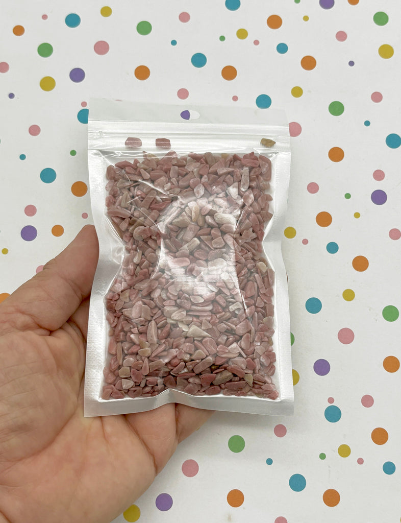 a hand holding a bag of pink and white sprinkles