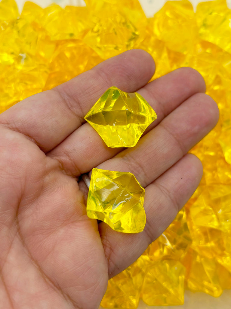a person holding a yellow diamond in their hand