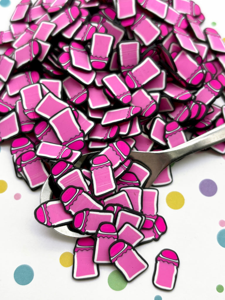 a spoon full of pink squares on a polka dot tablecloth