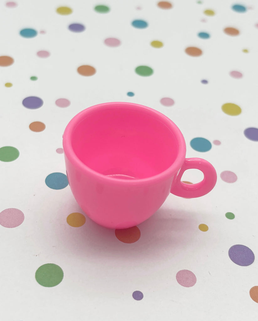 a pink cup sitting on top of a table