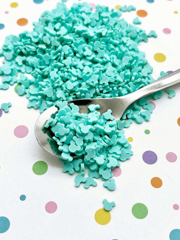 a spoon filled with blue sprinkles on top of a table