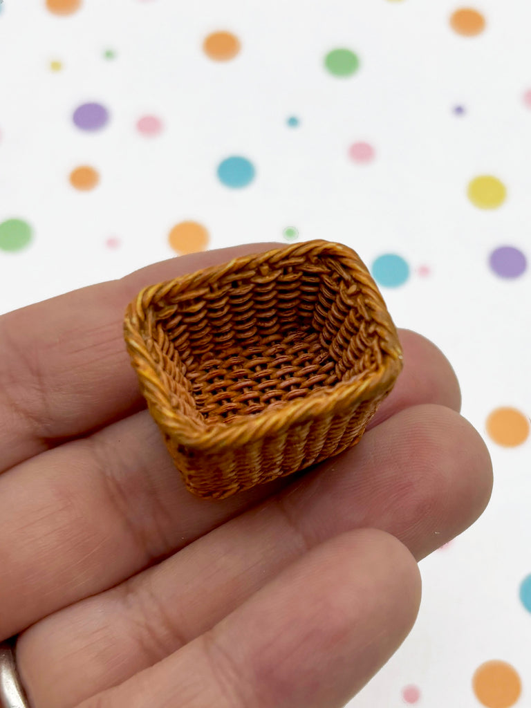 A small, brown woven basket is being held in a hand against a background of colorful polka dots.