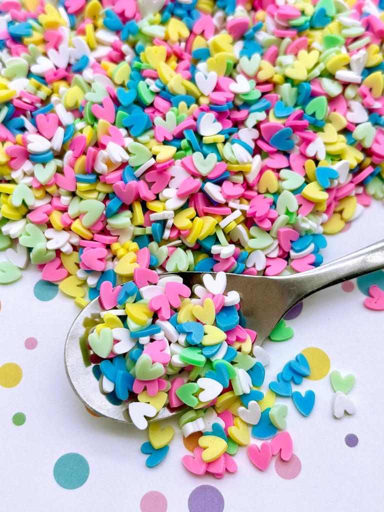 a spoon full of confetti sprinkles on a table