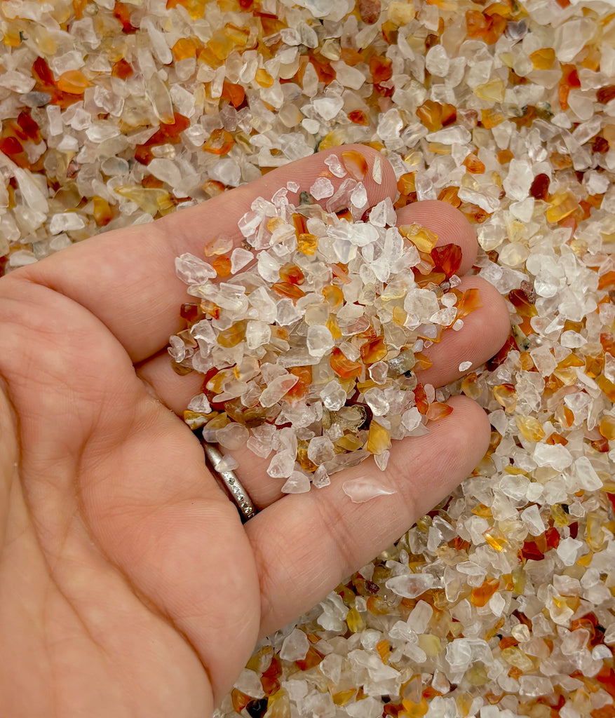 a person is holding a handful of sugar crystals