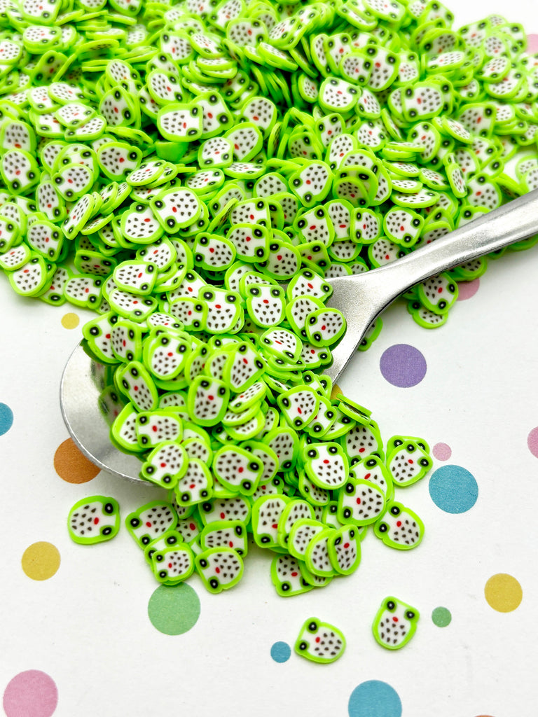 a pile of green and white beads next to a spoon