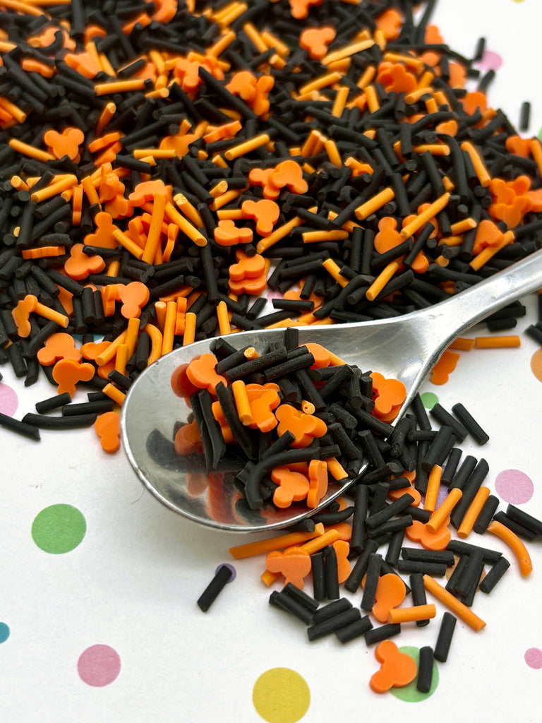 a spoon full of black and orange sprinkles