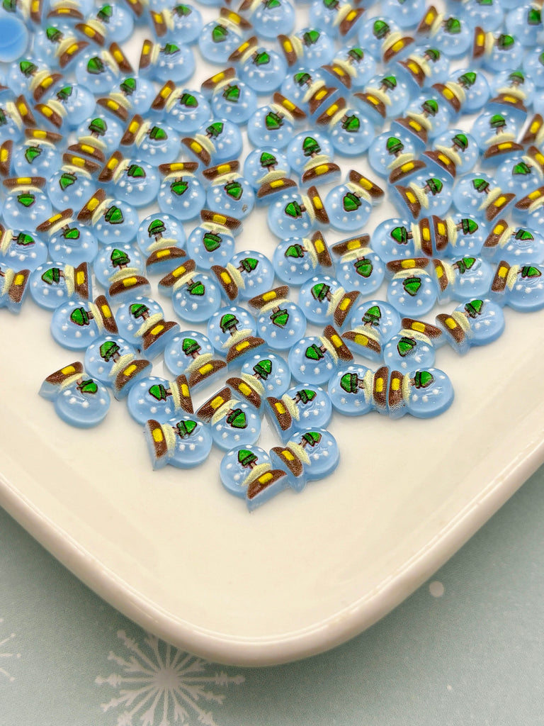 a white plate topped with lots of blue and green beads