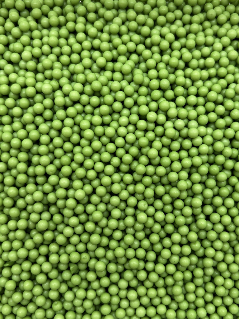 a large pile of green beads or spheres, possibly made of plastic or other materials.
