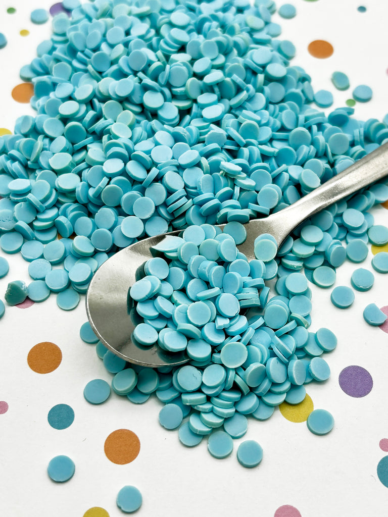 a spoon sitting on top of a pile of blue pills