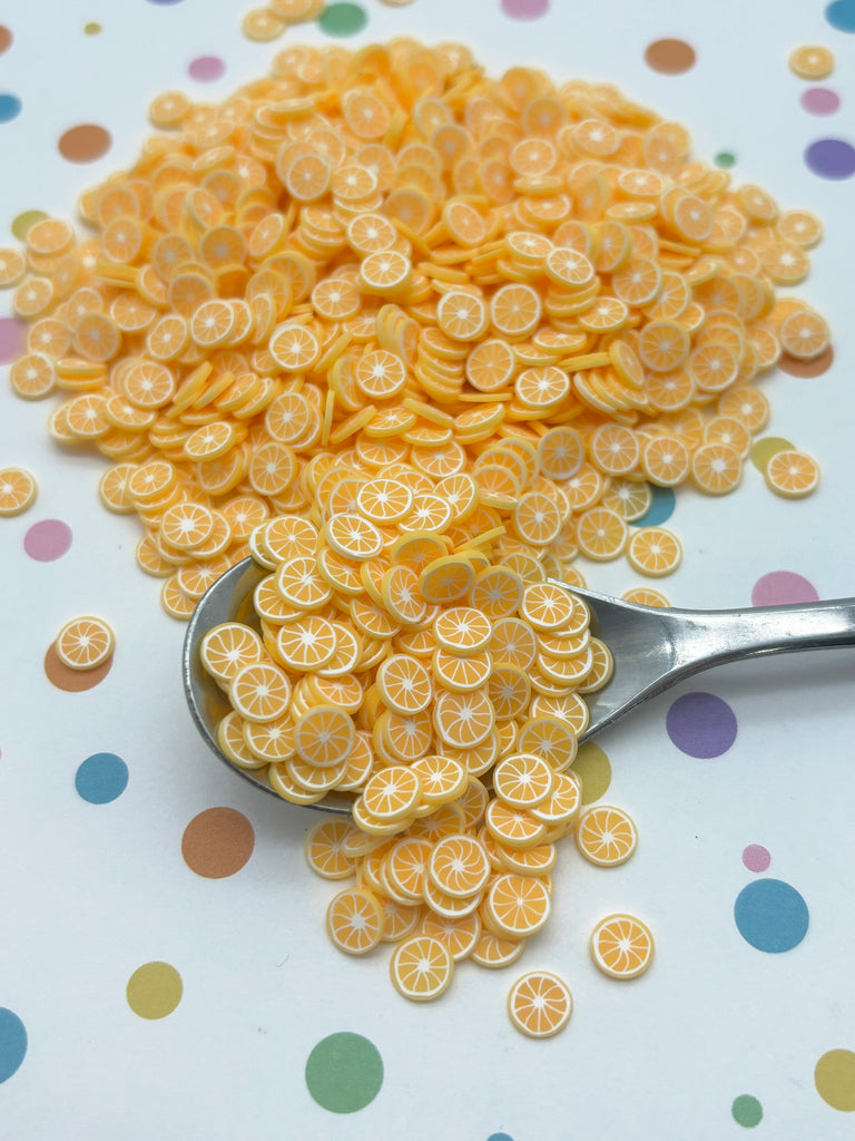 a spoon full of orange slices on a polka dot tablecloth