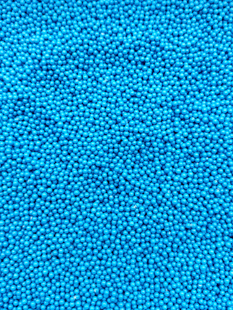 The image is a close-up of numerous small, round blue beads or spheres, creating a textured and visually striking pattern.