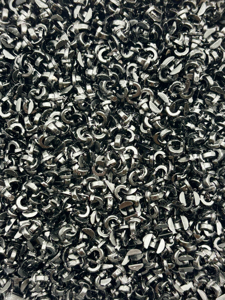 The image is a close-up of a pile of metal rings or links, with a textured and shiny appearance.