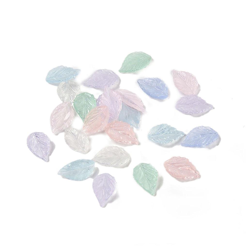 a collection of small, colorful glass leaves scattered on a white background.