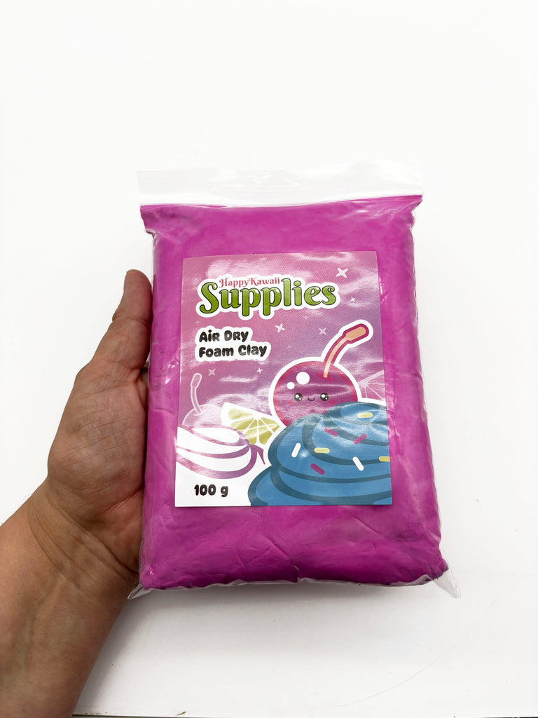 A hand holding a bag of pink air day foam clay.