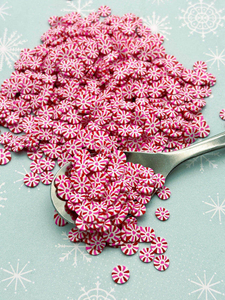 a spoon full of candy cane sprinkles on a table