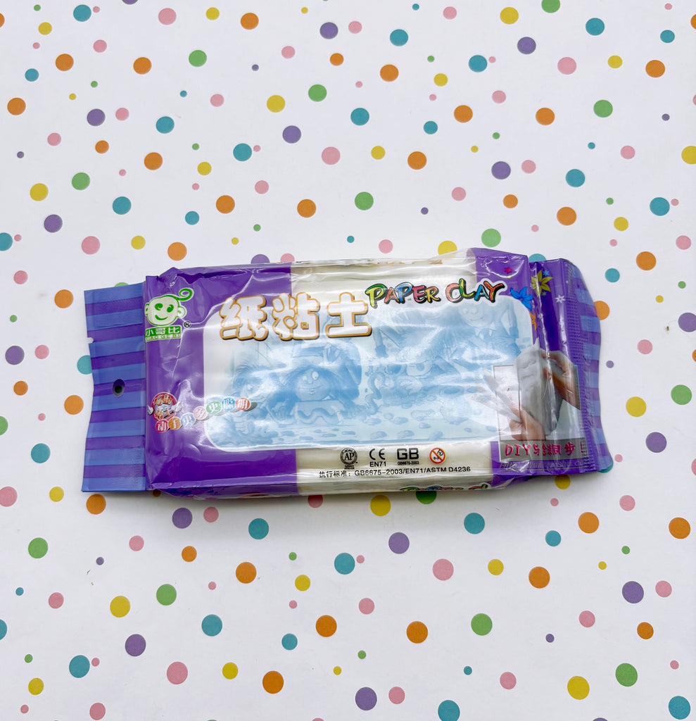 A package of paper clay is placed on a background with colorful polka dots.