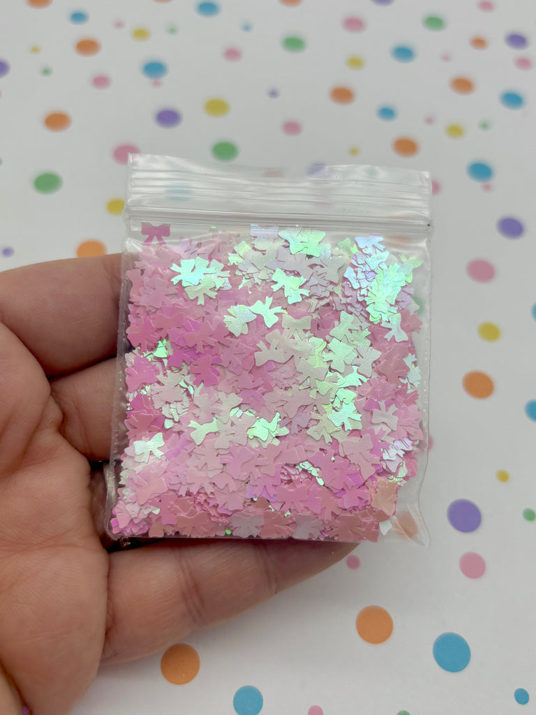 a hand holding a bag of pink and white confetti