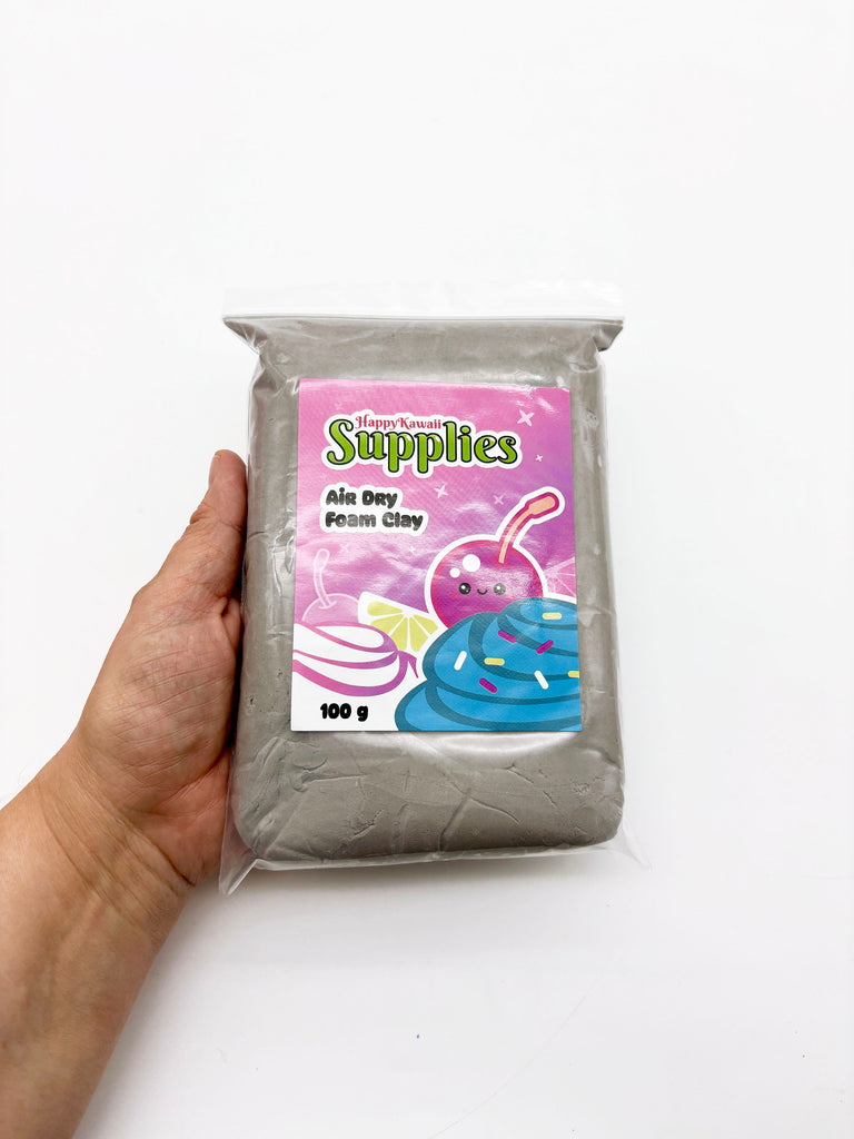 A hand holding a bag of air dry foam clay with a colorful label featuring a cartoon character.