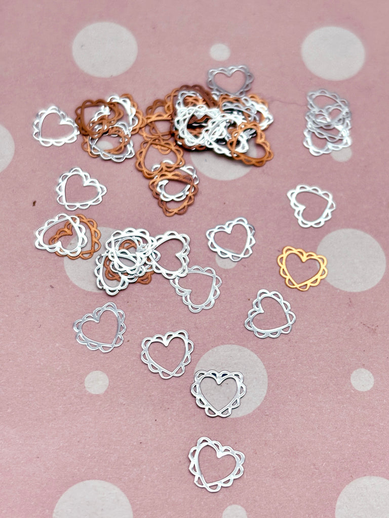 a bunch of small metal hearts on a table