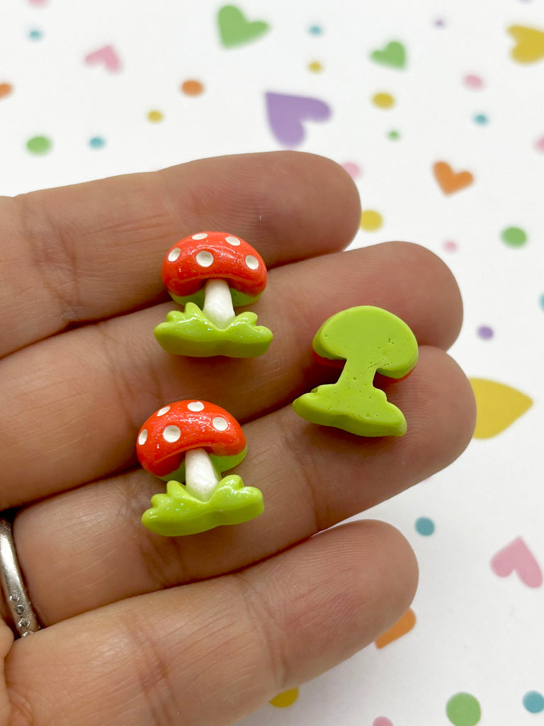 a person is holding two tiny mushrooms in their hand