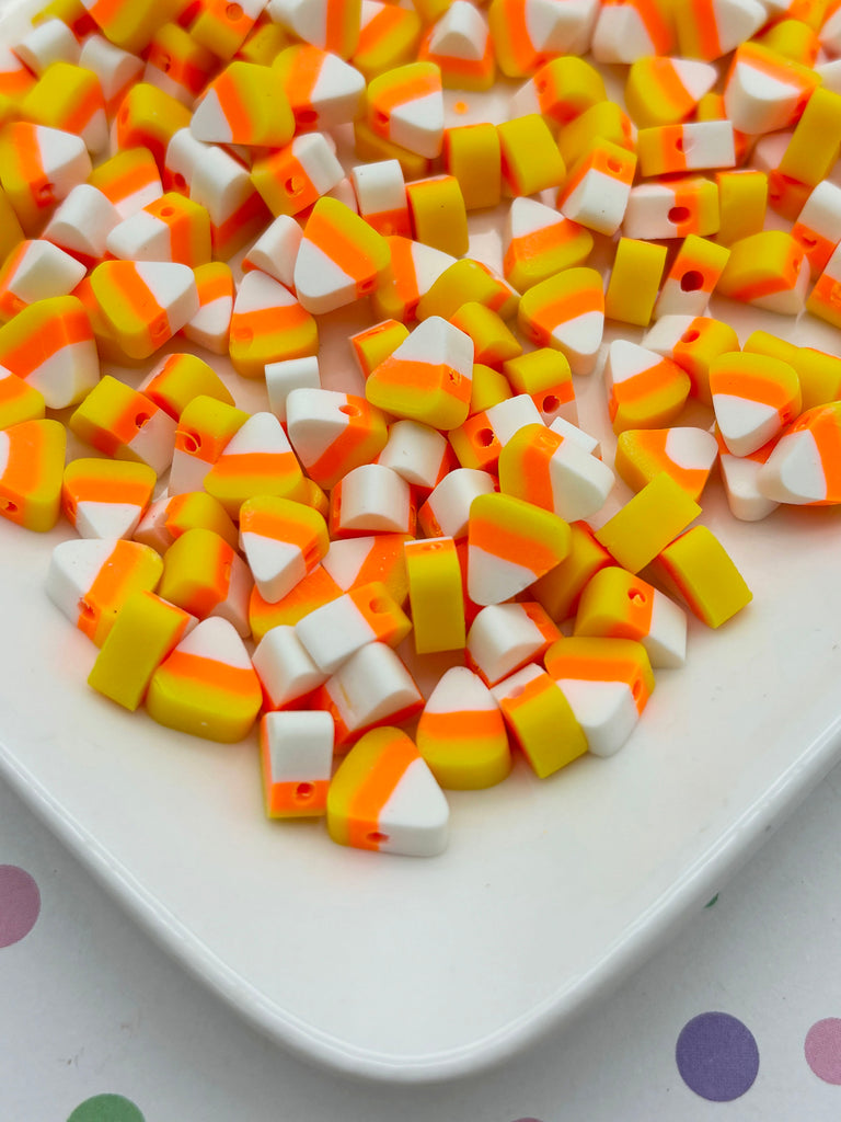 a white plate topped with orange and white candy corn