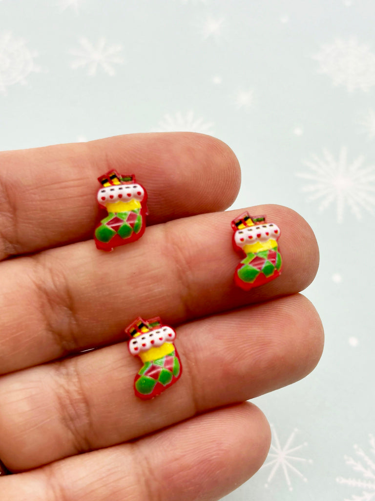 a hand holding a pair of christmas themed nail decals