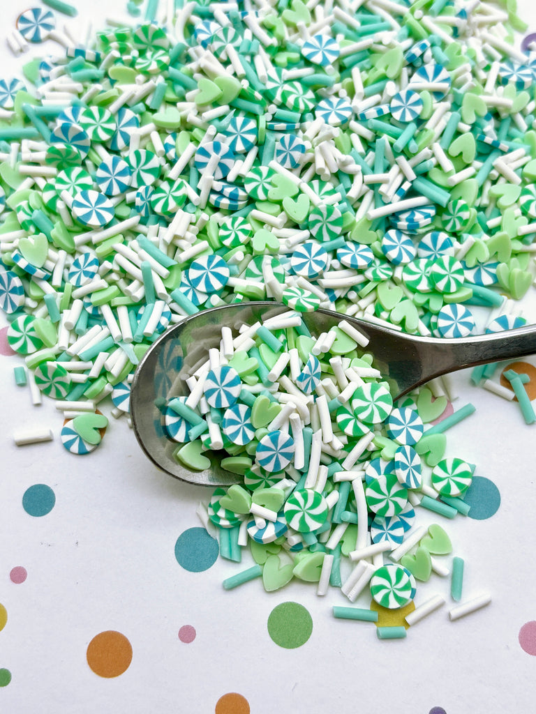 a spoon full of green and white sprinkles