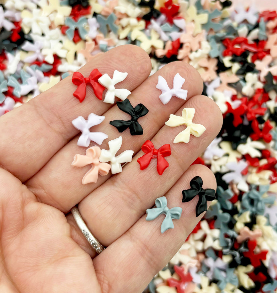 a person's hand holding a bunch of small bows