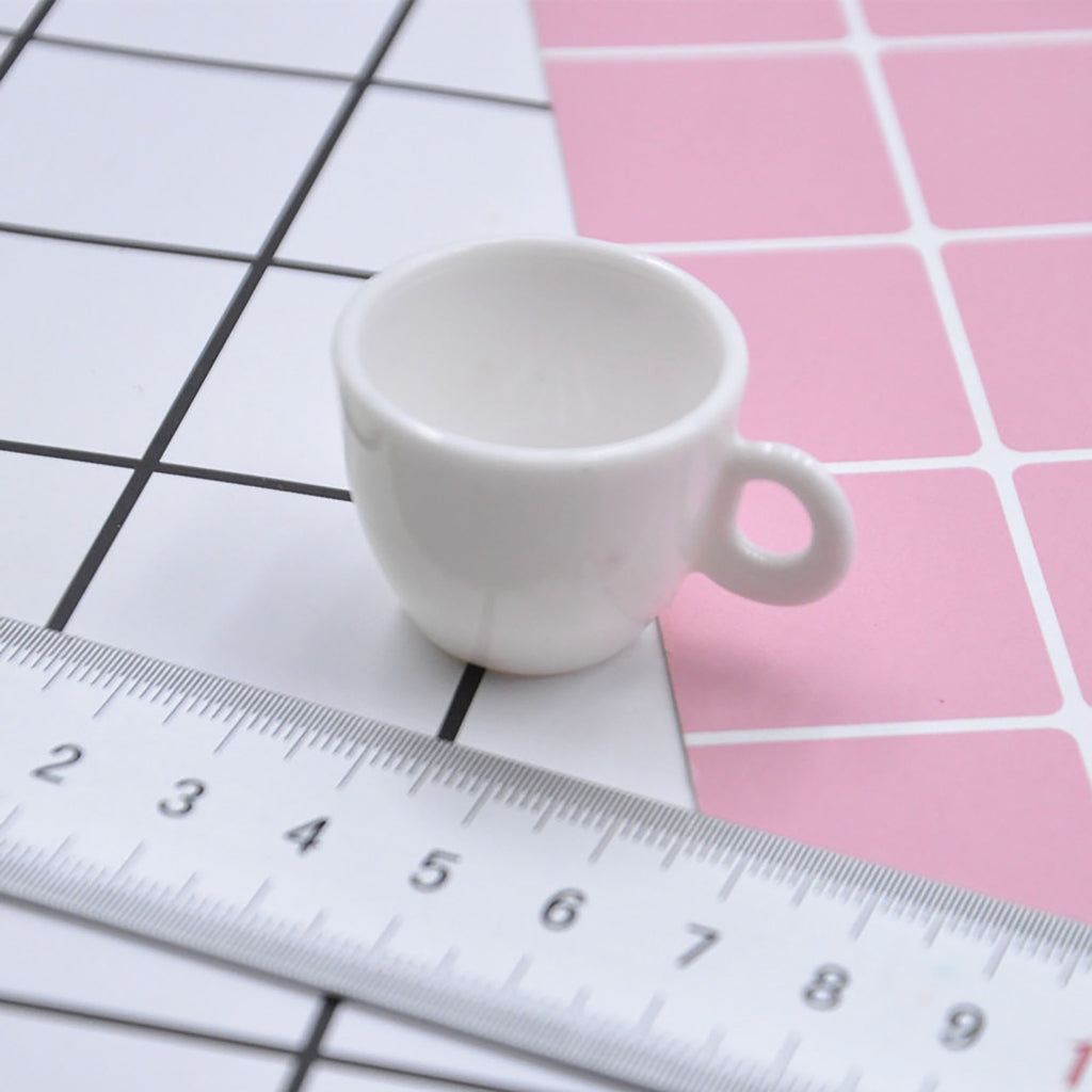 a white cup sitting on top of a table next to a ruler