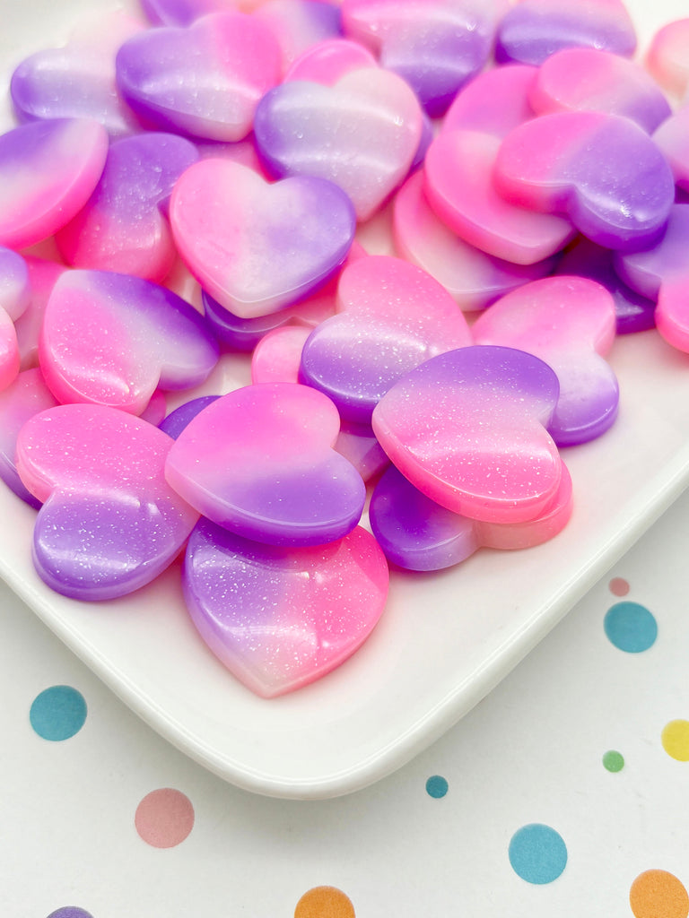 a white plate topped with lots of pink and purple hearts