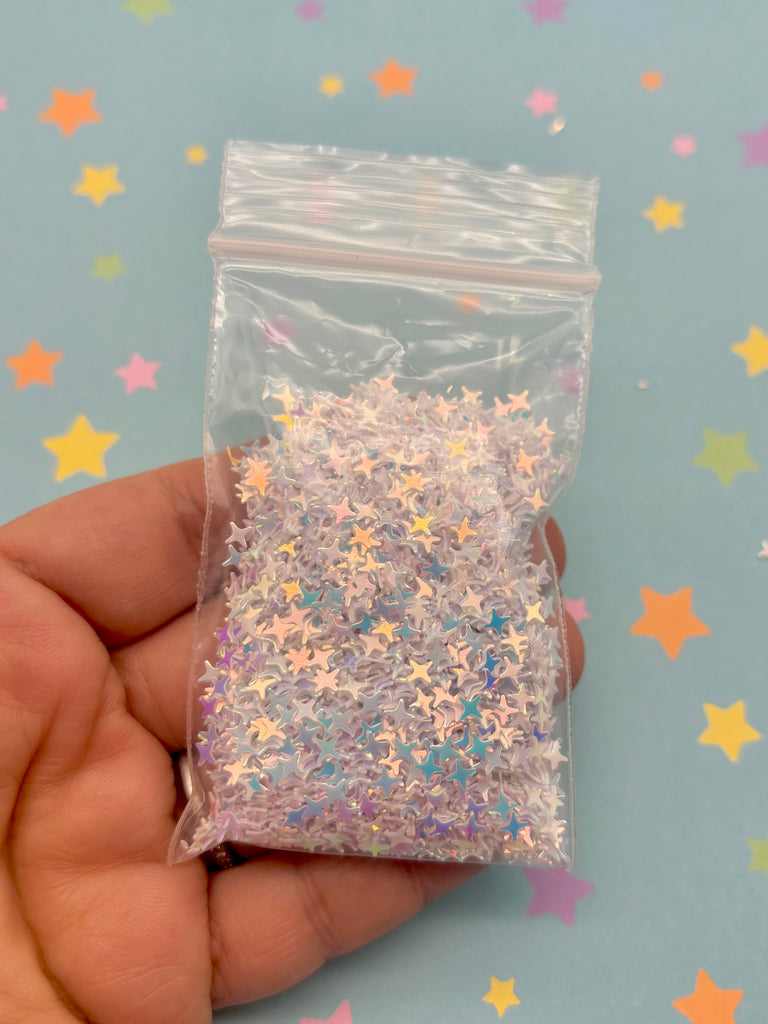 a hand holding a plastic bag filled with stars