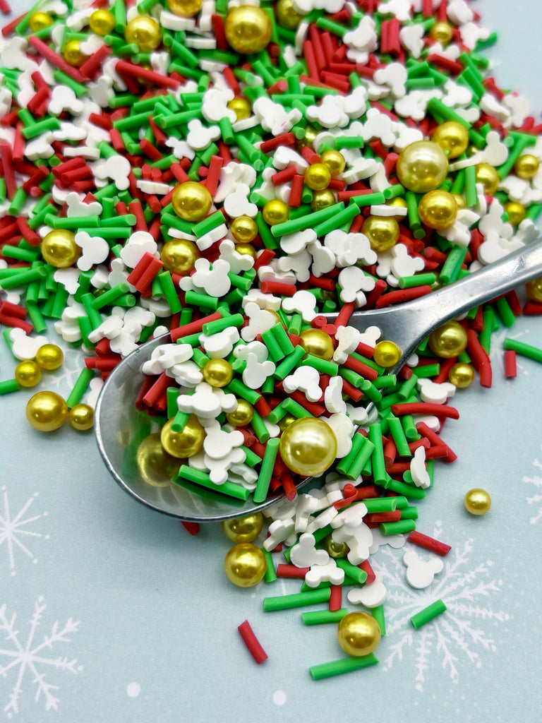 a spoon full of colorful sprinkles and gold and silver decorations