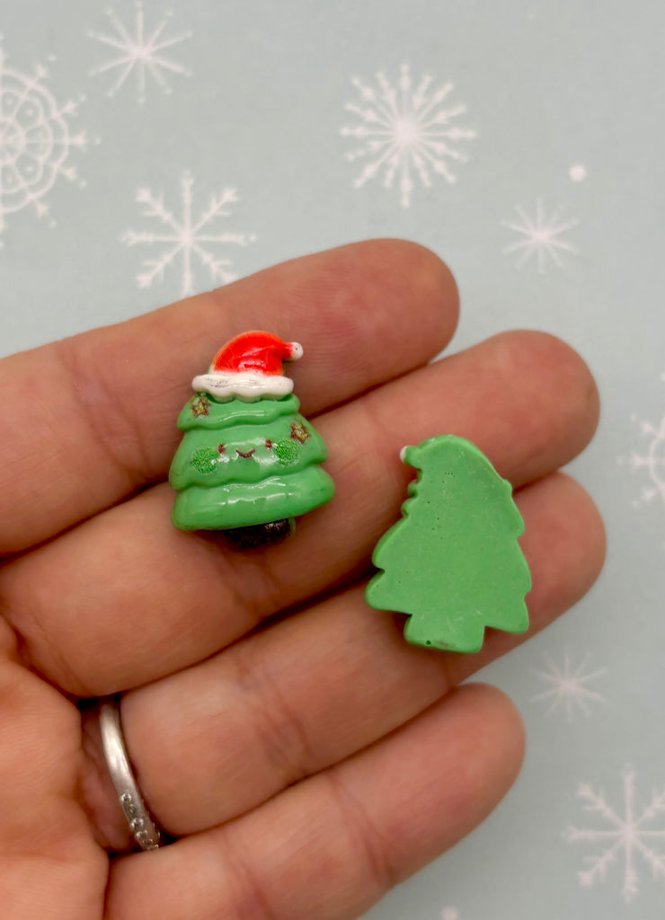 a hand holding a small green christmas tree