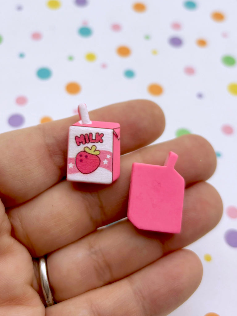 a person holding a small pink object in their hand