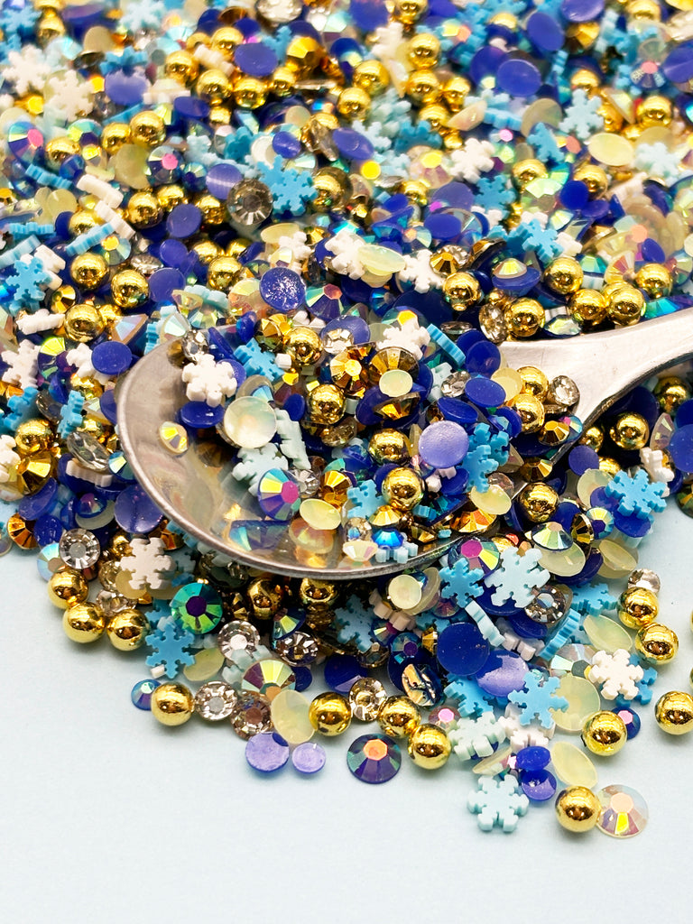 a spoon full of blue and gold sprinkles