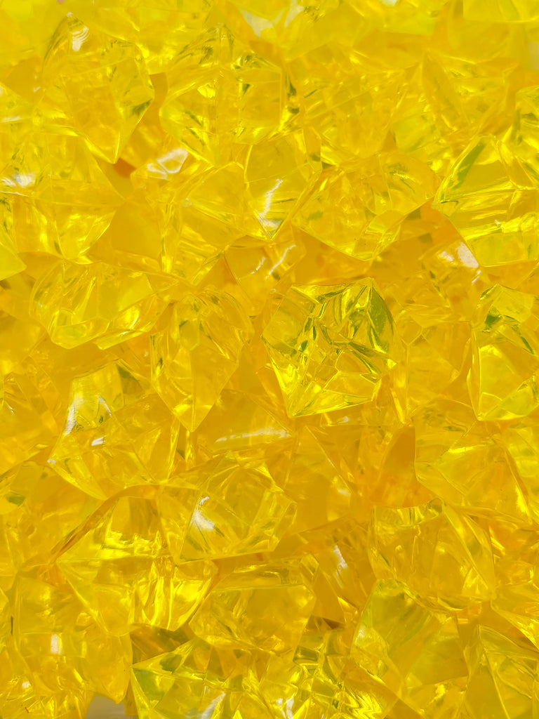 a pile of yellow glass beads sitting on top of a table