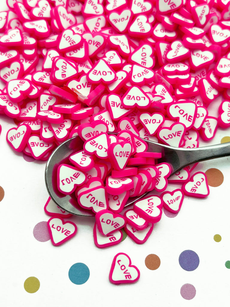 a spoon filled with lots of pink and white hearts