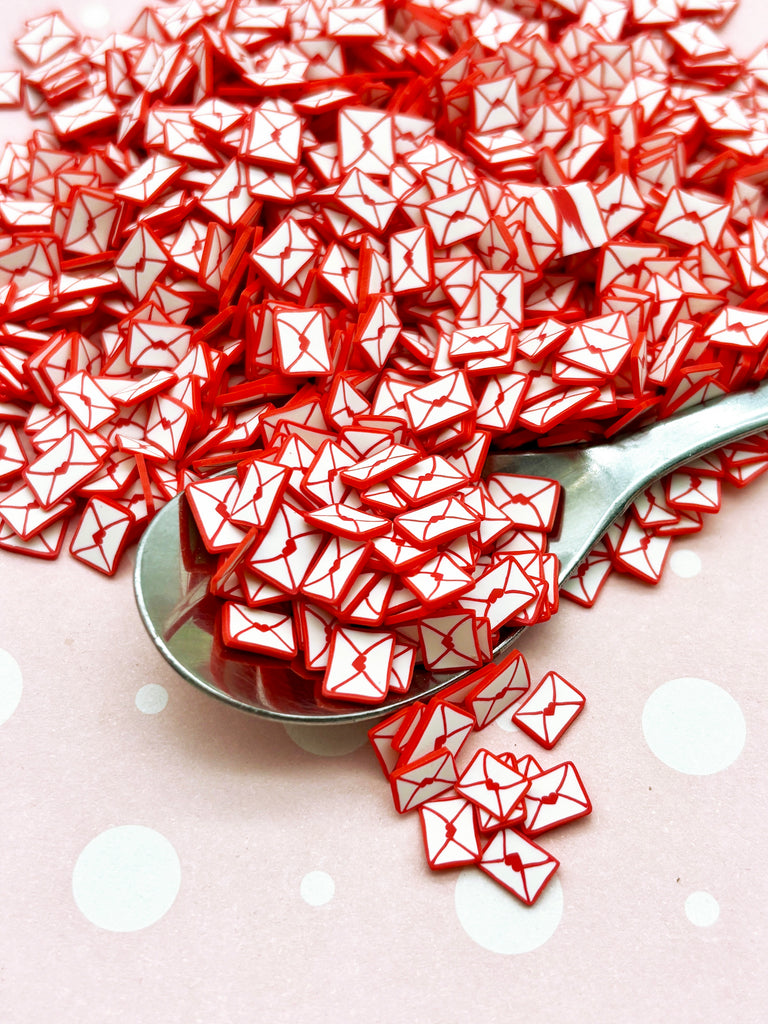 a spoon full of red glass cubes on a table