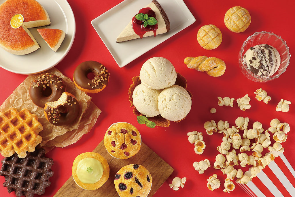 a variety of pastries and desserts on a red surface