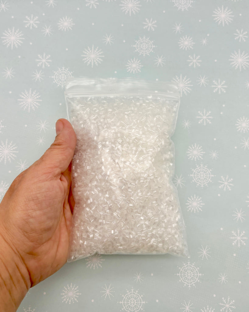 a hand holding a bag of white sugar