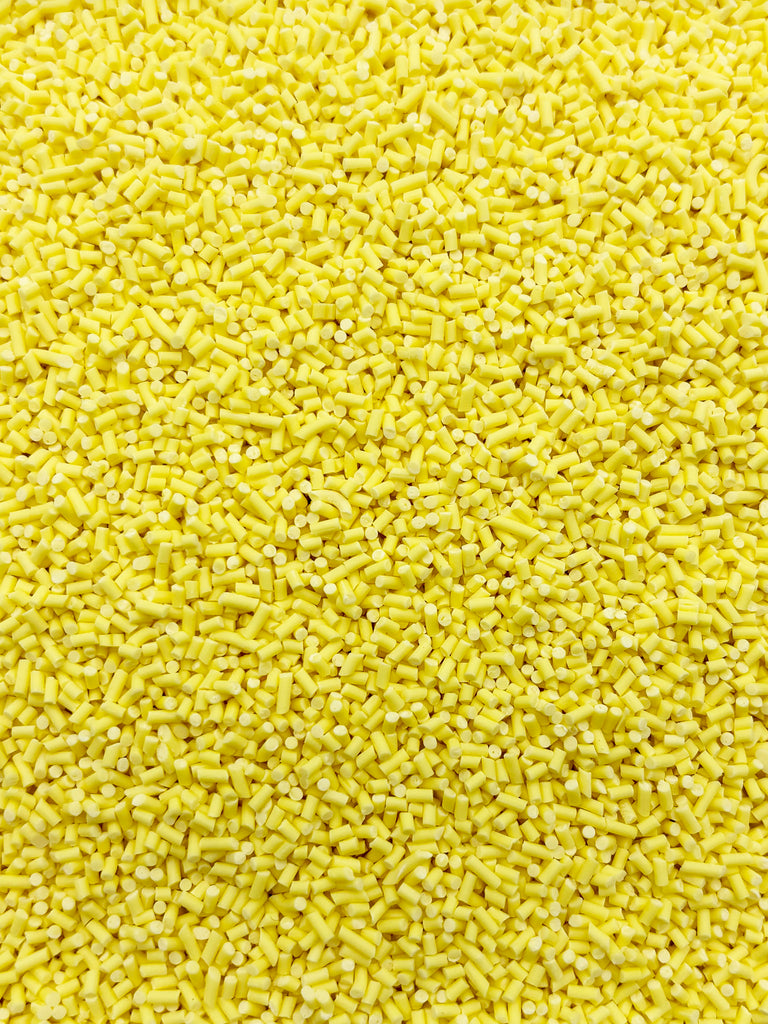 a large pile of small, yellow objects that appear to be a mix of small yellow and white objects.