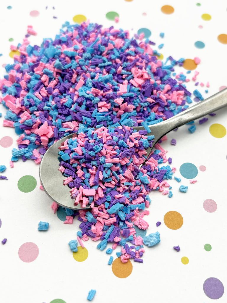 a spoon full of sprinkles on top of a table