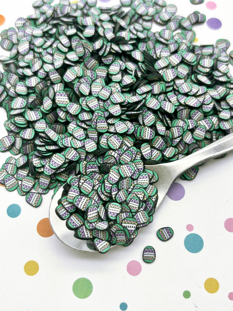 a spoon filled with lots of green and white buttons