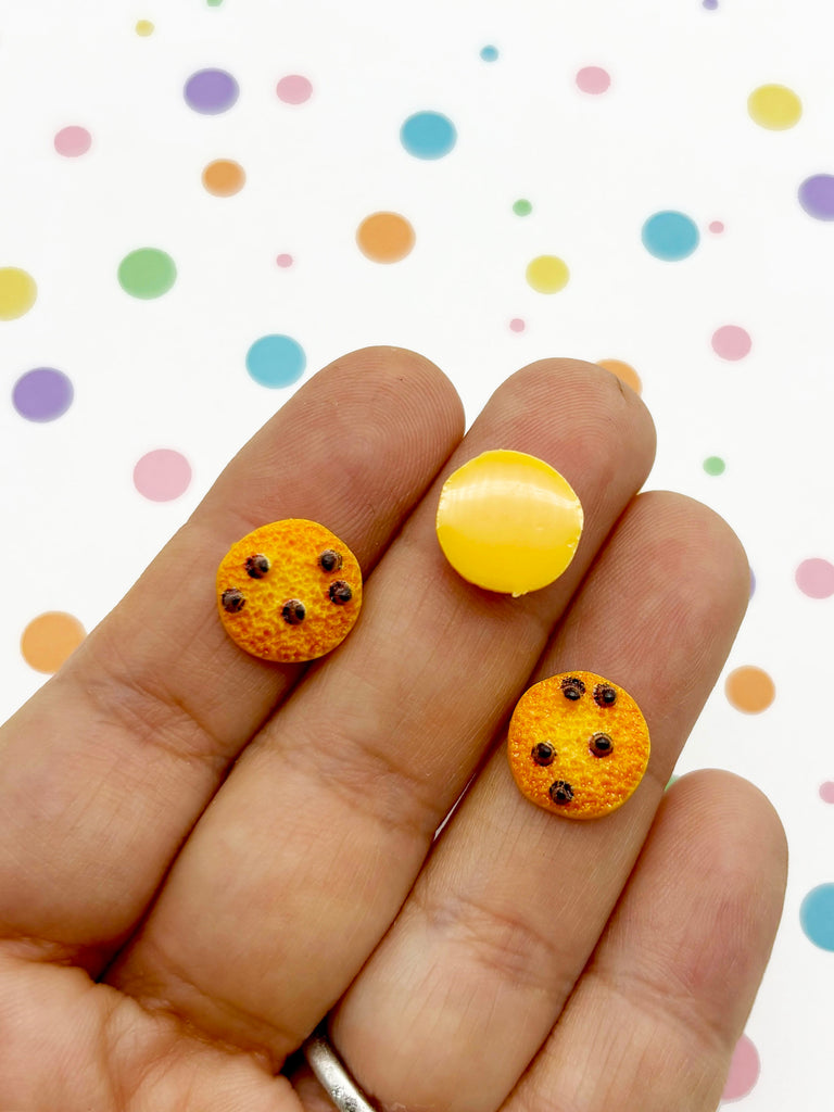 a hand holding a yellow and black polka dot nail art